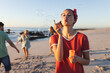Young Caucasian woman blows bubbles on a beach at sunset