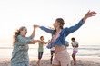 Young women dance on the beach at sunset, with copy space