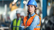 Focused woman engineer in safety gear standing at industrial site