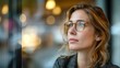 © arayabandit - The work environment, a focused working woman directs her gaze forward, exemplifying determination and concentration in the midst of the workplace atmosphere.