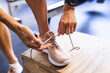 © Wavebreak Media - Close-up of a fit person tying their running shoe in a gym setting