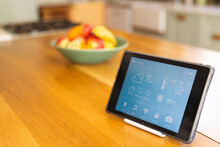 A tablet displaying smart home controls sits on a kitchen counter