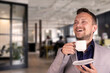 © PRO Balance - Portrait of a young attractive, smiling businessman with a cup of coffee in the office