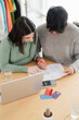 © Studio Marmellata - Young couple intently reviewing documents and working on a laptop at home