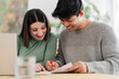 © Studio Marmellata - Young couple intently reviewing documents and working on a laptop at home
