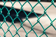 Close-up green metal chain link fence with blurred background