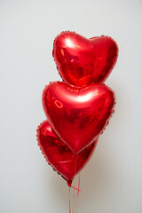 red heart balloons with helium on a white background in a bunch