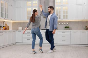 Wall Mural - Happy lovely couple dancing together in kitchen