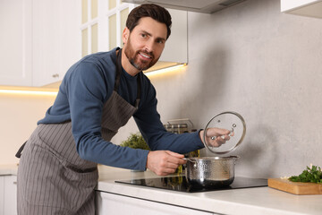 Wall Mural - Man cooking soup on cooktop in kitchen