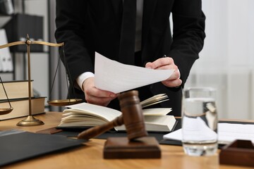 Poster - Lawyer working with document at wooden table, closeup