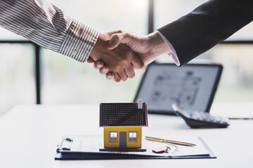 Wall Mural - Businessman shaking hands with real estate agent in office after reaching home purchase agreement.