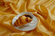 a cup of coffee with a croissant on yellow background