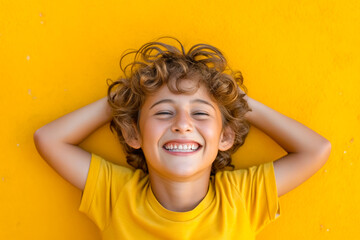 Poster - Young boy with curly hair smiles for the camera.