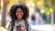 Smiling African American girl walking in university park using mobile cell phone shopping online or texting messages on cellphone, Female student holding smartphone standing outdoors, generative ai