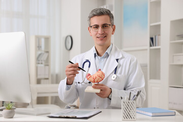 Poster - Gastroenterologist showing human stomach model at table in clinic