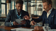 © MP Studio - Two professionals engaged in a serious discussion with one holding a tablet, sitting at a wooden table in a modern office environment, with a laptop and various documents laid out in front of them.