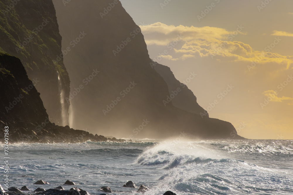 Volcanic rock cliffs Achadas da Cruz in backlit sunlight. Waves of the ...