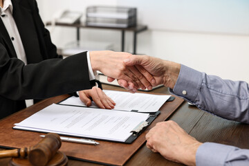 Wall Mural - Lawyer shaking hands with client in office, closeup