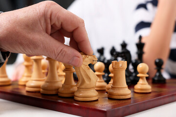 Wall Mural - Senior man playing chess with his grandson indoors, closeup