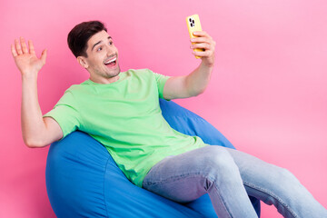 Canvas Print - Photo of young man friendly recording video waving palm send greetings to subscribers self portrait phone isolated on pink color background