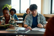 © Drazen - University students studying while attending at lecture in classroom.