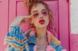 a girl in hip hop jacket and jeans, making lips with lipstick on pink wall