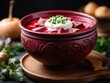A steaming plate of delicious traditional Ukrainian borscht with sour cream and herbs.