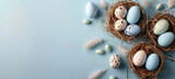 Fototapeta Tulipany - Easter Eggs Nestled in Straw on Pastel Blue Background