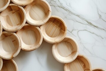 Poster - A stack of wooden bowls arranged neatly on a sleek marble counter. Perfect for adding a touch of rustic elegance to any kitchen or dining area