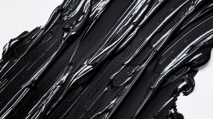 Black paint close-up on a white surface. Suitable for abstract art projects or backgrounds