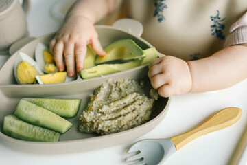 Wall Mural - first blw baby food, little baby eating organic vegetables with BLW method. Infant eating healthy food. self feeding