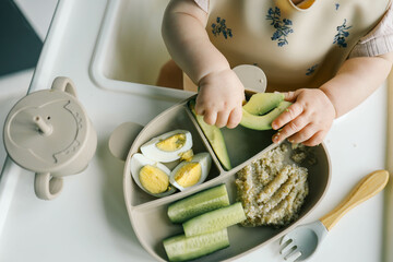 Wall Mural - first blw baby food, little baby eating organic vegetables with BLW method. Infant eating healthy food. self feeding