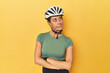 © Asier - Cyclist middle aged woman with helmet and gloves posed confused, feels doubtful and unsure.