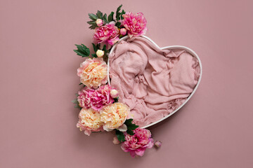 Wall Mural - heart made of wood decorated with peonies. basket for a photo shoot of newborns. pink peony. heart