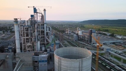 Canvas Print - Cement factory with high concrete plant structure and tower crane at industrial production site. Manufacture and global industry concept.