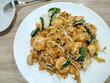 Selective focus. Stir fried flat rice noodle or char kway teow that is famous among Indonesian as breakfast or another meal. Chinese cuisine. Seafood stir fried.
