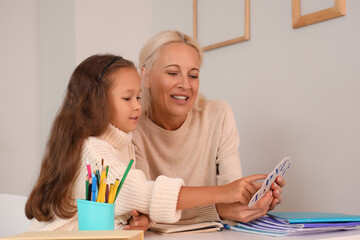 Sticker - Little girl with her grandmother studying at home