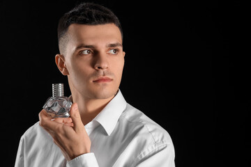 Poster - Young man with perfume on dark background, closeup