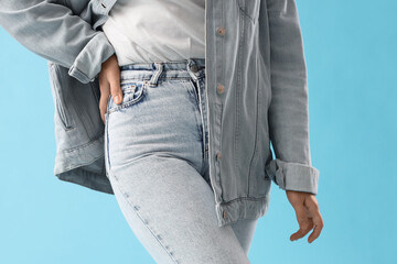 Wall Mural - Stylish young woman in denim clothes on blue background, closeup