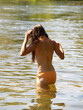 Young Woman In River From Back Wearing Orange Bikini
