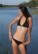Slim Woman In Black Bikini Standing Next To River