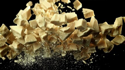 Canvas Print - Pieces of white chocolate fly up and fall down. Filmed on a high-speed camera at 1000 fps. High quality FullHD footage