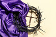 Crown of thorns with purple fabric and nails on beige background