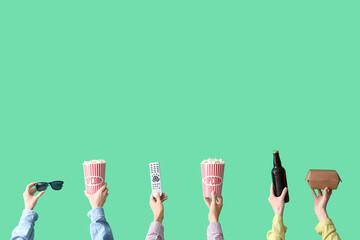 Wall Mural - Many hands with buckets of popcorn, beer and TV remote on green background