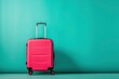 a pink suitcase is sitting in front of a blue wall