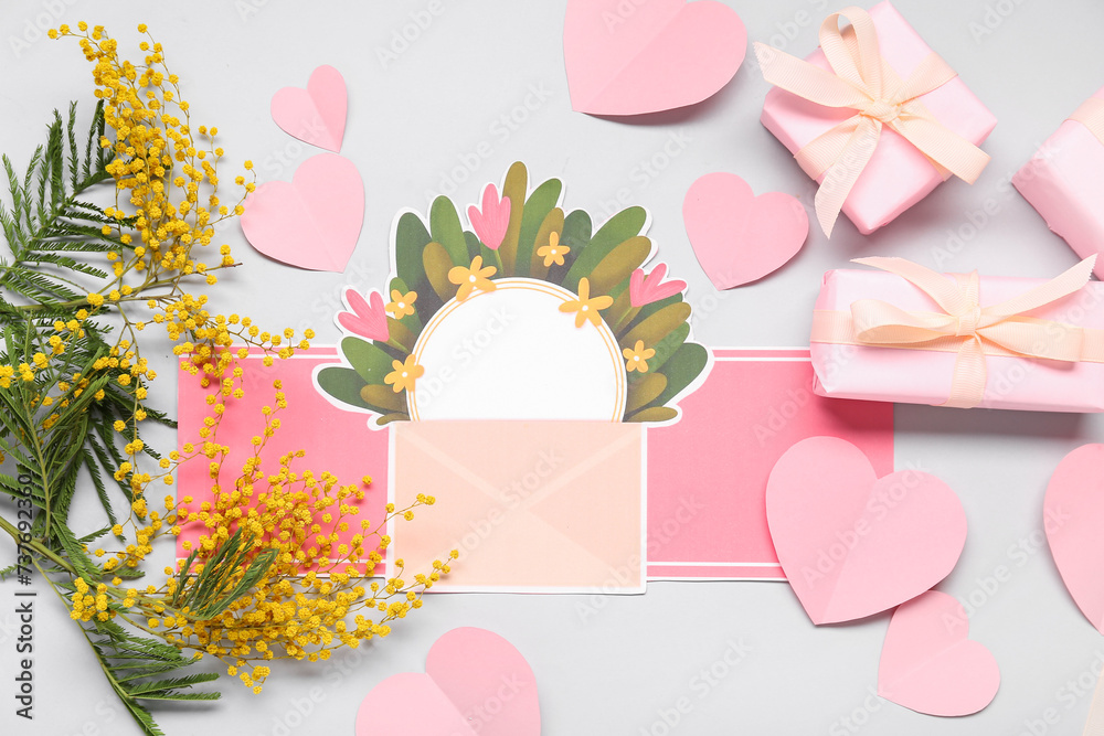 Composition with blank card, mimosa and gift boxes on white background