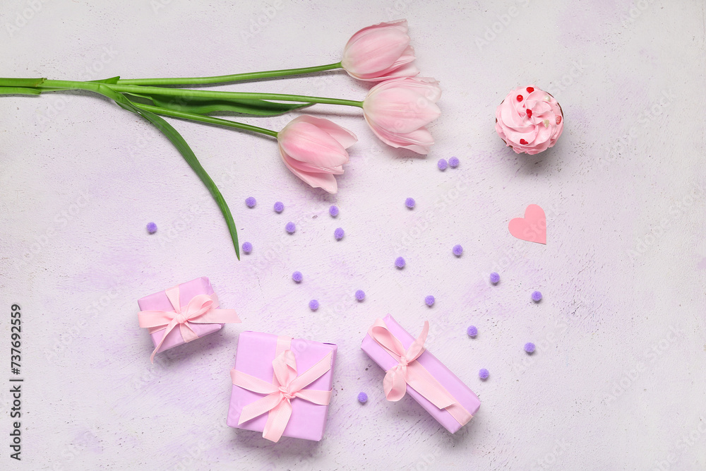 Presents, pink tulips and cupcake on light background