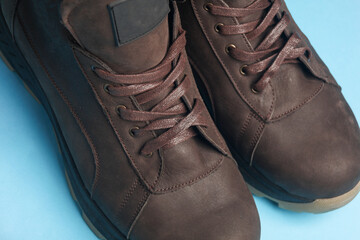 Wall Mural - Pair of Brown leather boots on blue background close up