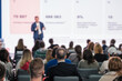© Anton Gvozdikov - Blurred view of a professional speaker at a business seminar engaging with an audience.