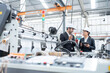 European male engineer and Asian female senior official Owners and business partners of industrial plants Wear a suit to talk and inspect the operation of plastic and steel export production machinery